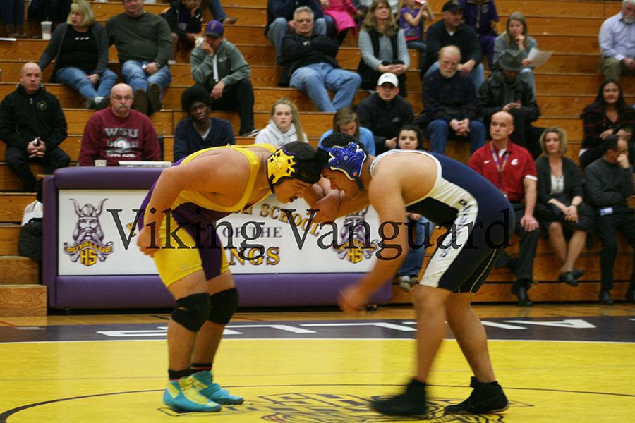 Junior Ryan Tyler Espinoza ties up with his opponent at the beginning of his match.