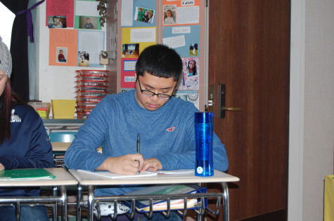 Senior Christian Buensuceso takes notes in his AP Literature class.