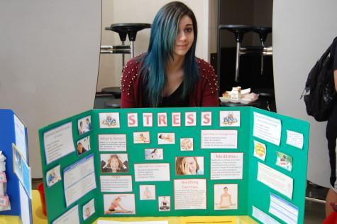 Senior and HOSA member Dalal Alghanmi poses behind her display featuring the affects of stress. 