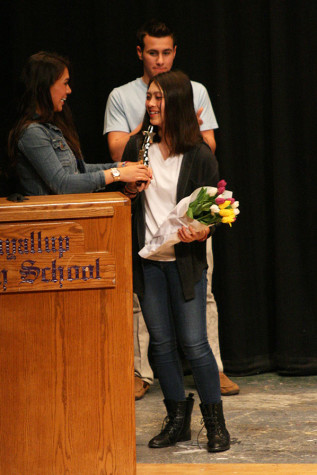 Emcee senior Celeste Grinnell awards her sister, junior Olivia Grinnell with the first place trophy. The Viking Varieties talent show was held April 9 in the auditorium.