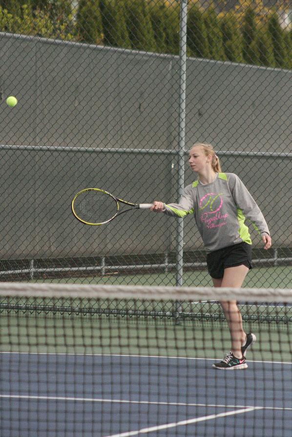 Sophomore Scotney Carlson warms up before her doubles match begins with sophomore Jessi Oyama as her partner. The girls tennis team played against Spanaway Lake High School April 14 and won with a score of 4-1.