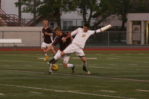 Junior Trevor Lee tries to fight off a Bethel defender and gain control of the ball. The boys soccer team won against Bethel High School with a score of 7-0 April 21.