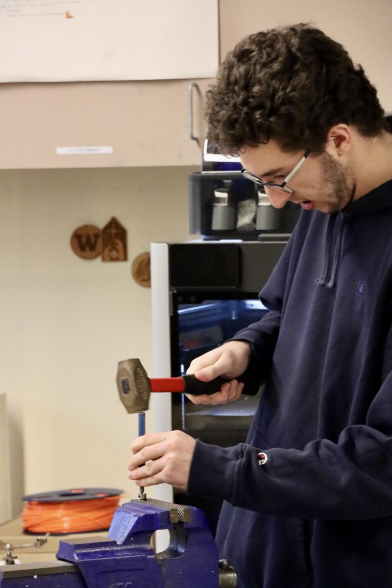 Senior Spencer Hainey is fine tuning his equipment to add onto the robot afterschool in robotics club February 15th.